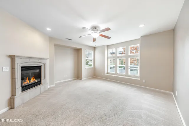an empty room with windows and fireplace