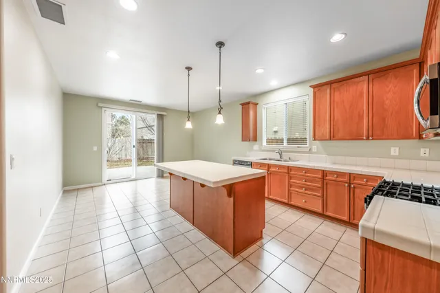 a kitchen with stainless steel appliances granite countertop a stove a sink dishwasher and a refrigerator