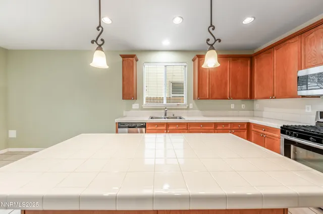 a large white kitchen with a large window a sink and a counter top space