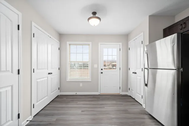 a view of a kitchen with wooden floor and a window