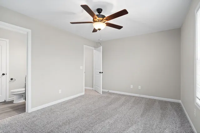 an empty room with closet and fan