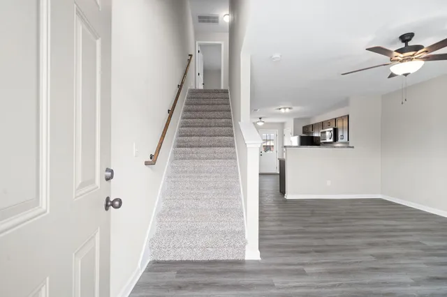 a view of a hallway with wooden floor and staircase
