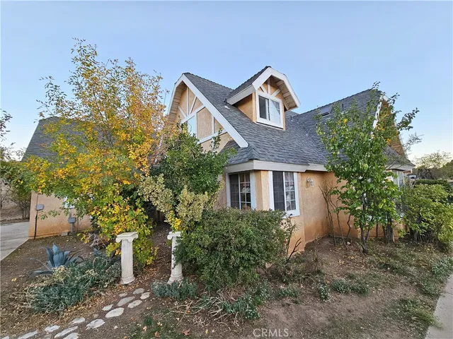 a front view of a house with plants and trees