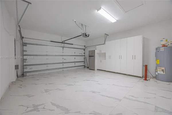 a view of a kitchen with kitchen island white cabinets and stainless steel appliances