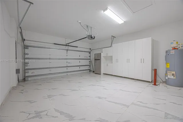 a view of a kitchen with kitchen island white cabinets and stainless steel appliances