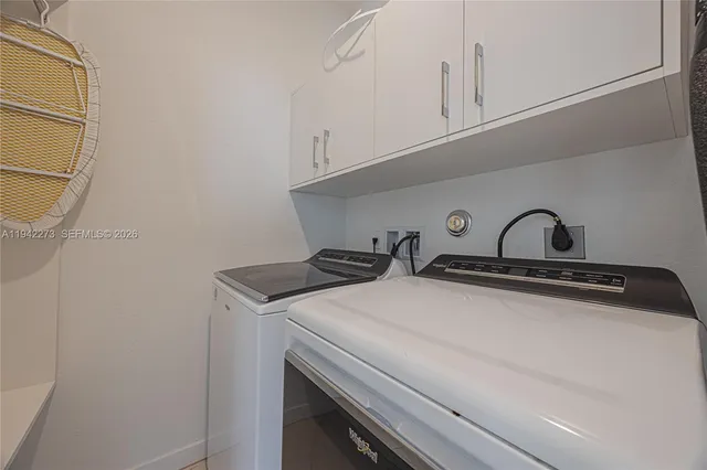 a view of kitchen with granite countertop cabinets and white appliances