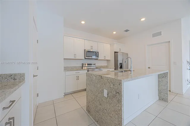 a kitchen with stainless steel appliances granite countertop a sink and a stove