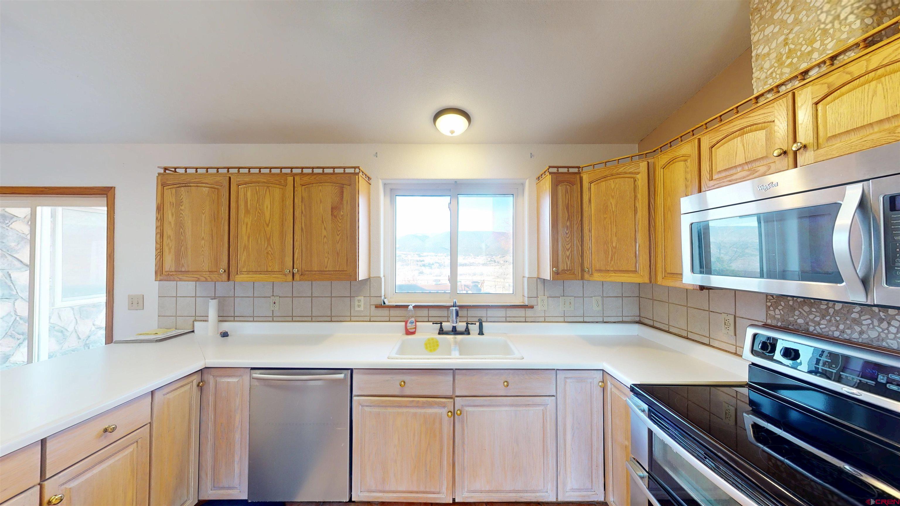 39865 Nelson Road Paonia, CO 81428 - Photo 13 of 38 a kitchen with a sink stove and cabinets