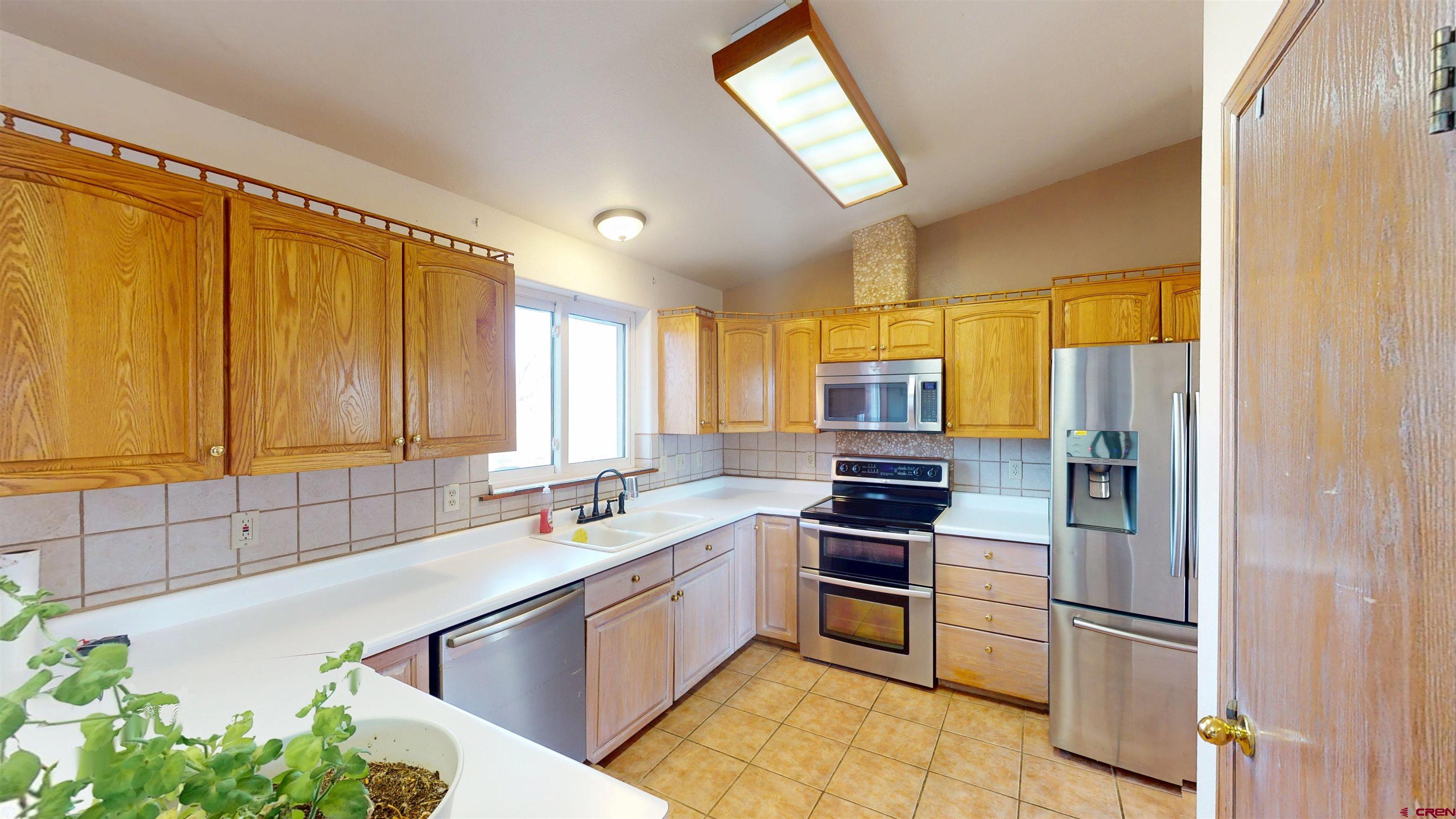 39865 Nelson Road Paonia, CO 81428 - Photo 14 of 38 a kitchen with stainless steel appliances a sink cabinets and a window