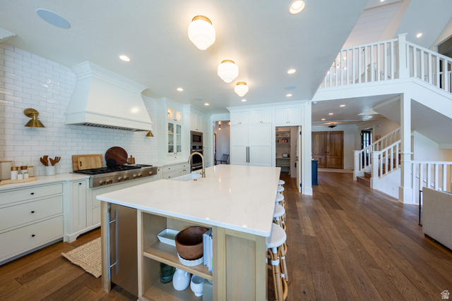 630 East Center Street Alpine, UT 84004 - Photo 20 of 115 Gourmet kitchen featuring an oversized island with countertop seating, a professional-grade range with a custom range hood, white subway tile backsplash, and extensive cabinetry
