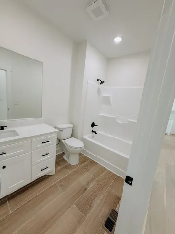 a bathroom with a bathtub sink mirror and toilet