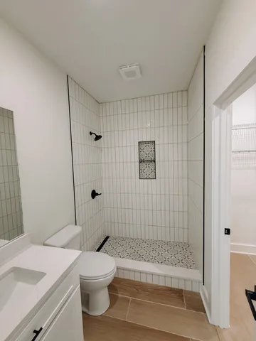 a bathroom with a sink a toilet and shower