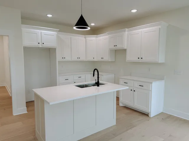 a kitchen with white cabinets and sink