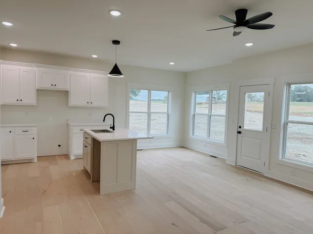 a open kitchen with cabinets stove and a sink
