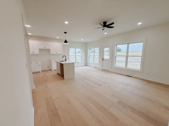 an empty room with chandelier and windows