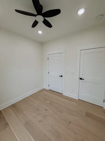 an empty room with ceiling fan and window