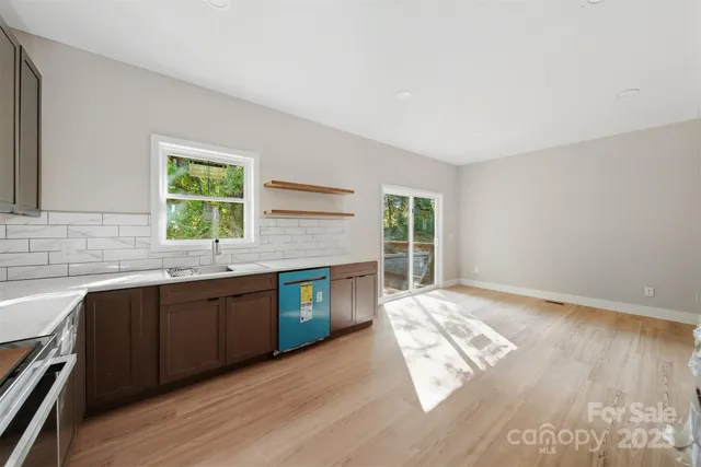 a kitchen with stainless steel appliances granite countertop a sink cabinets and wooden floor