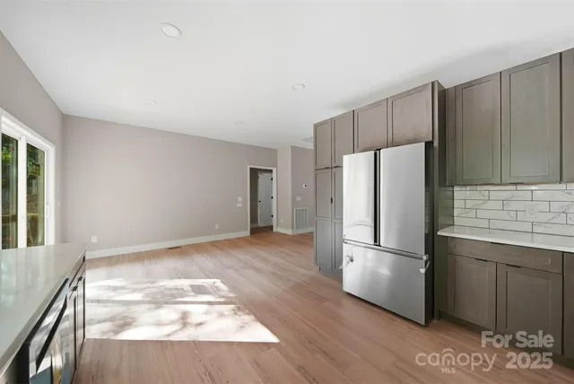 a kitchen with a refrigerator and wooden floor