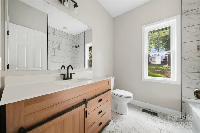 a bathroom with a sink a toilet and a window
