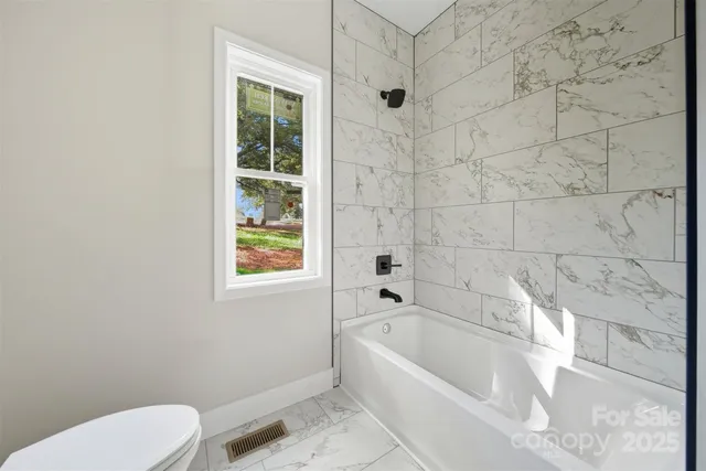 a white bath tub sitting next to a toilet