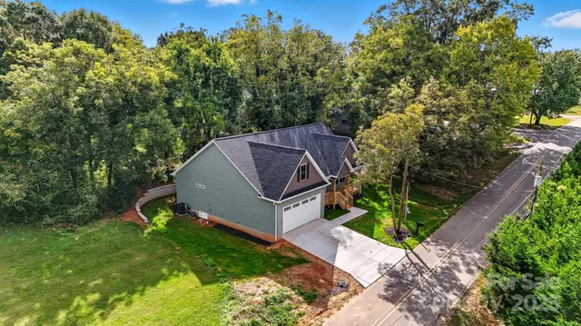 a aerial view of a house with a big yard and large trees