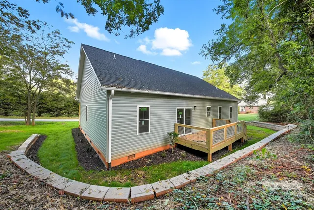 a front view of house with garden and trees
