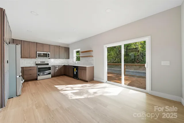a large kitchen with a stove a refrigerator and a large window