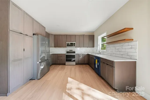 a large kitchen with stainless steel appliances sink a microwave and cabinets