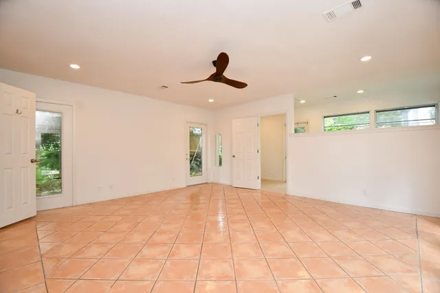 a view of an empty room and kitchen