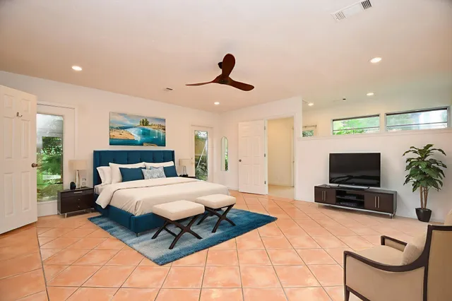 a bedroom with a bed a couch and a flat screen tv