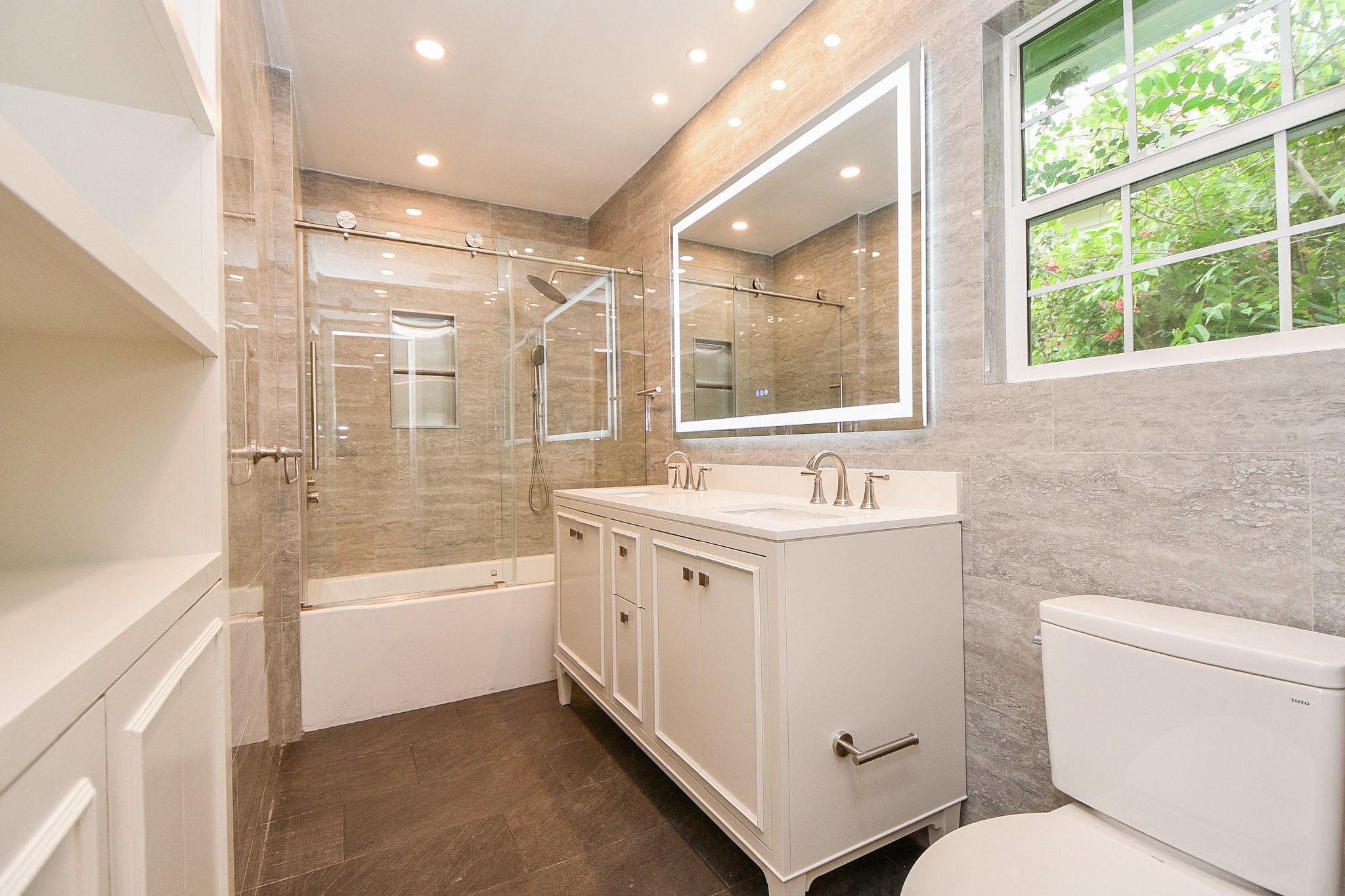 5015 Grape Street Houston, TX 77096 - Photo 15 of 28 a bathroom with a double vanity sink toilet mirror and bathtub