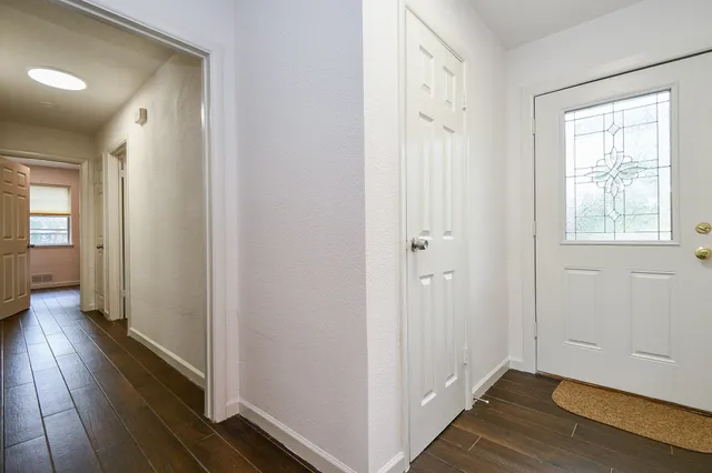 a view of a hallway with wooden floor and closet area