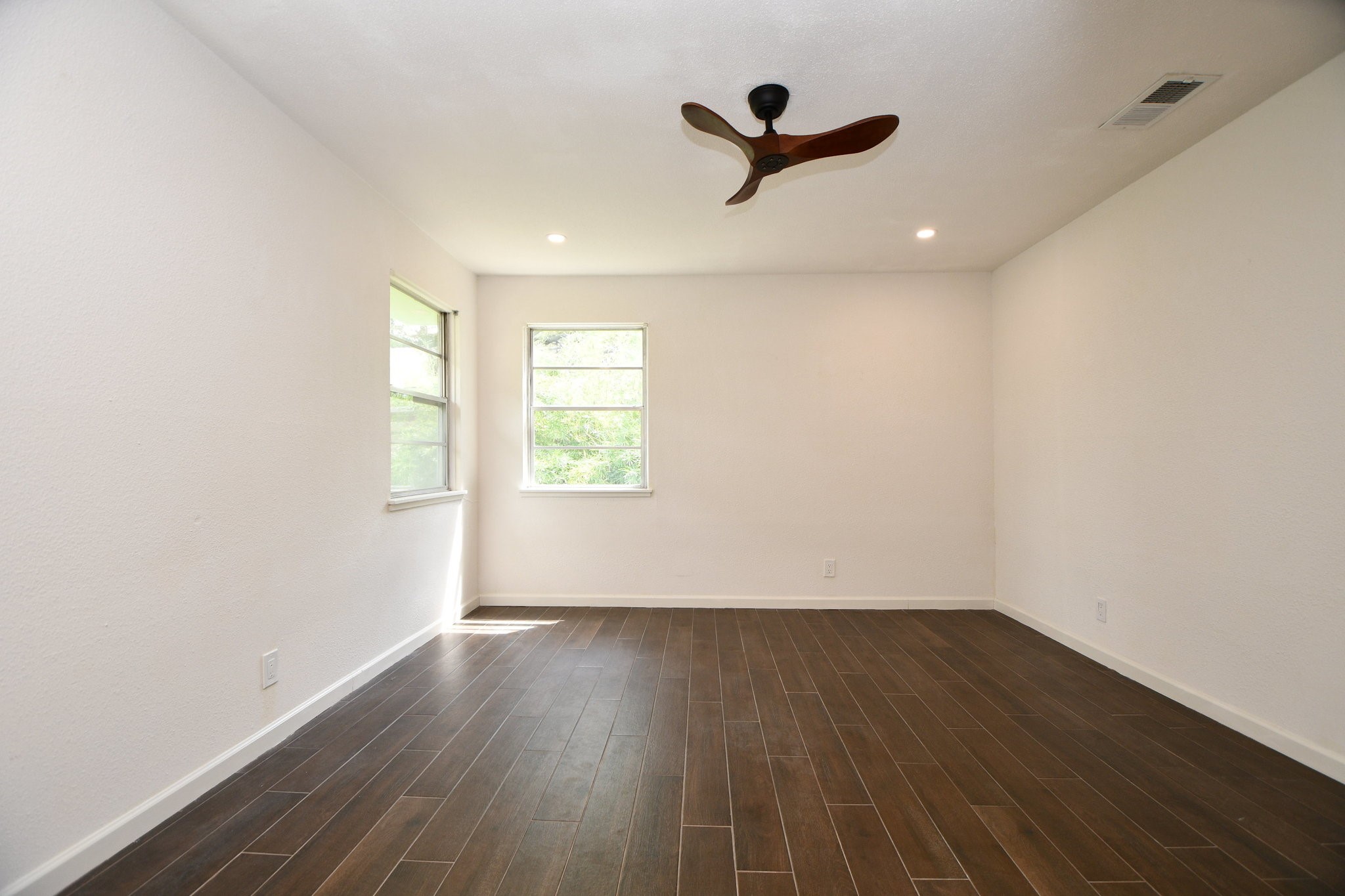 5015 Grape Street Houston, TX 77096 - Photo 18 of 28 an empty room with wooden floor and windows