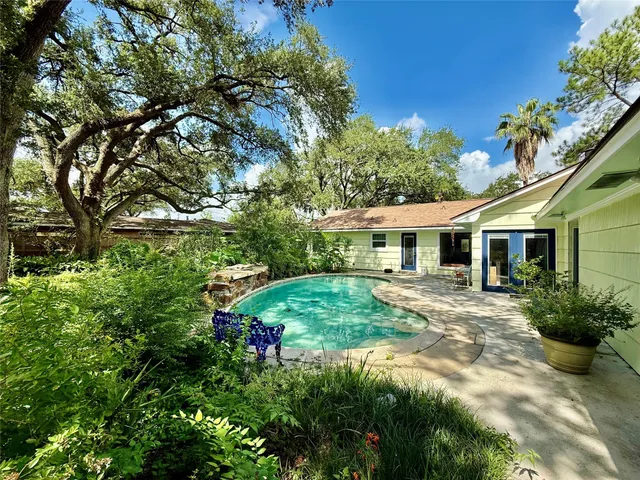 a view of an house with backyard and a tree