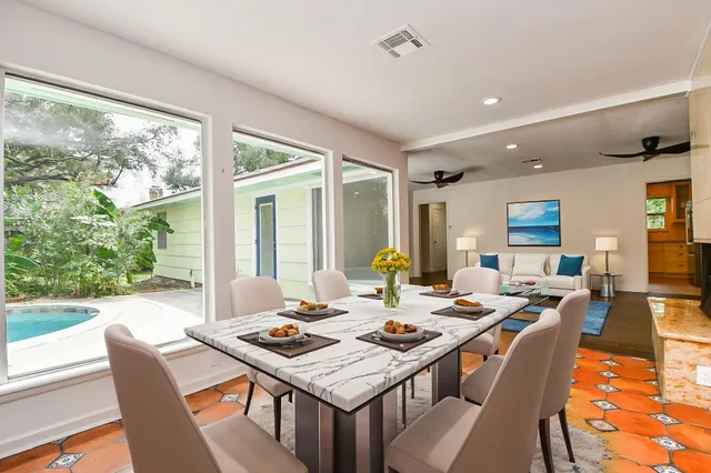 a dining room with wooden floor a glass table and chairs