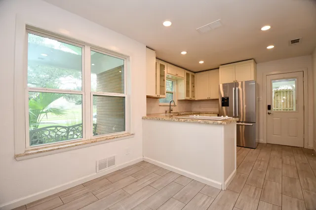a kitchen with a refrigerator window and wooden floor