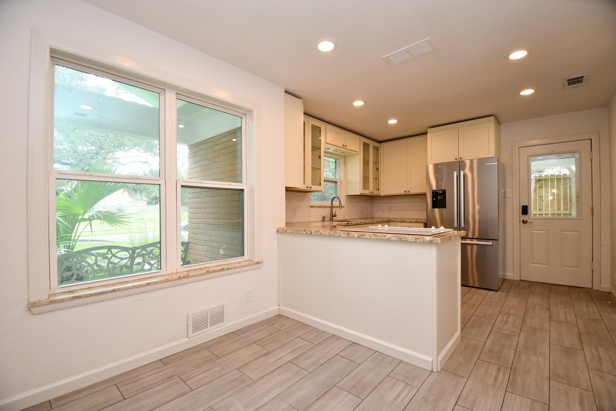 5015 Grape Street Houston, TX 77096 - Photo 9 of 28 a kitchen with a refrigerator window and wooden floor