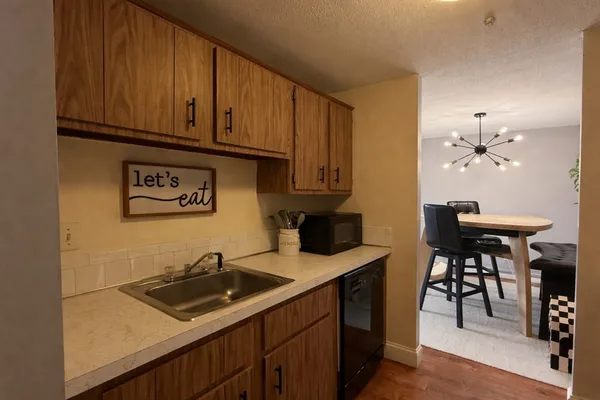 a kitchen with a sink cabinets and wooden floor