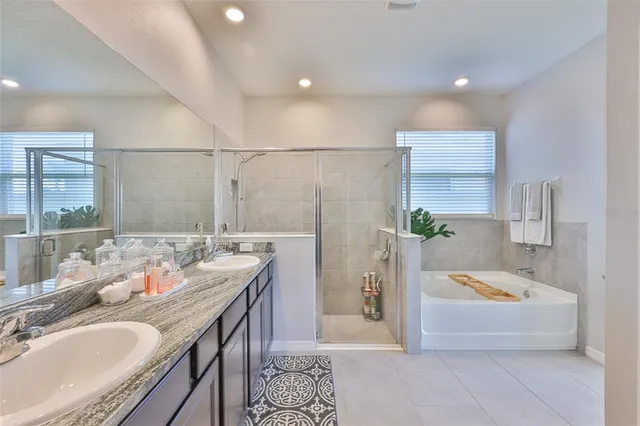 a spacious bathroom with a granite countertop tub sink and mirror