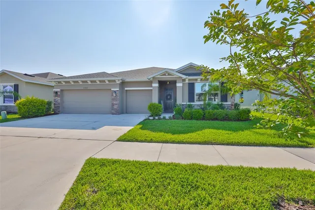 a front view of a house with a yard and garage