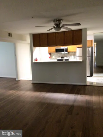 a white refrigerator freezer and a stove sitting inside of a kitchen