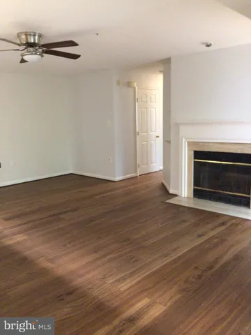 a view of a livingroom with wooden floor a fireplace and window
