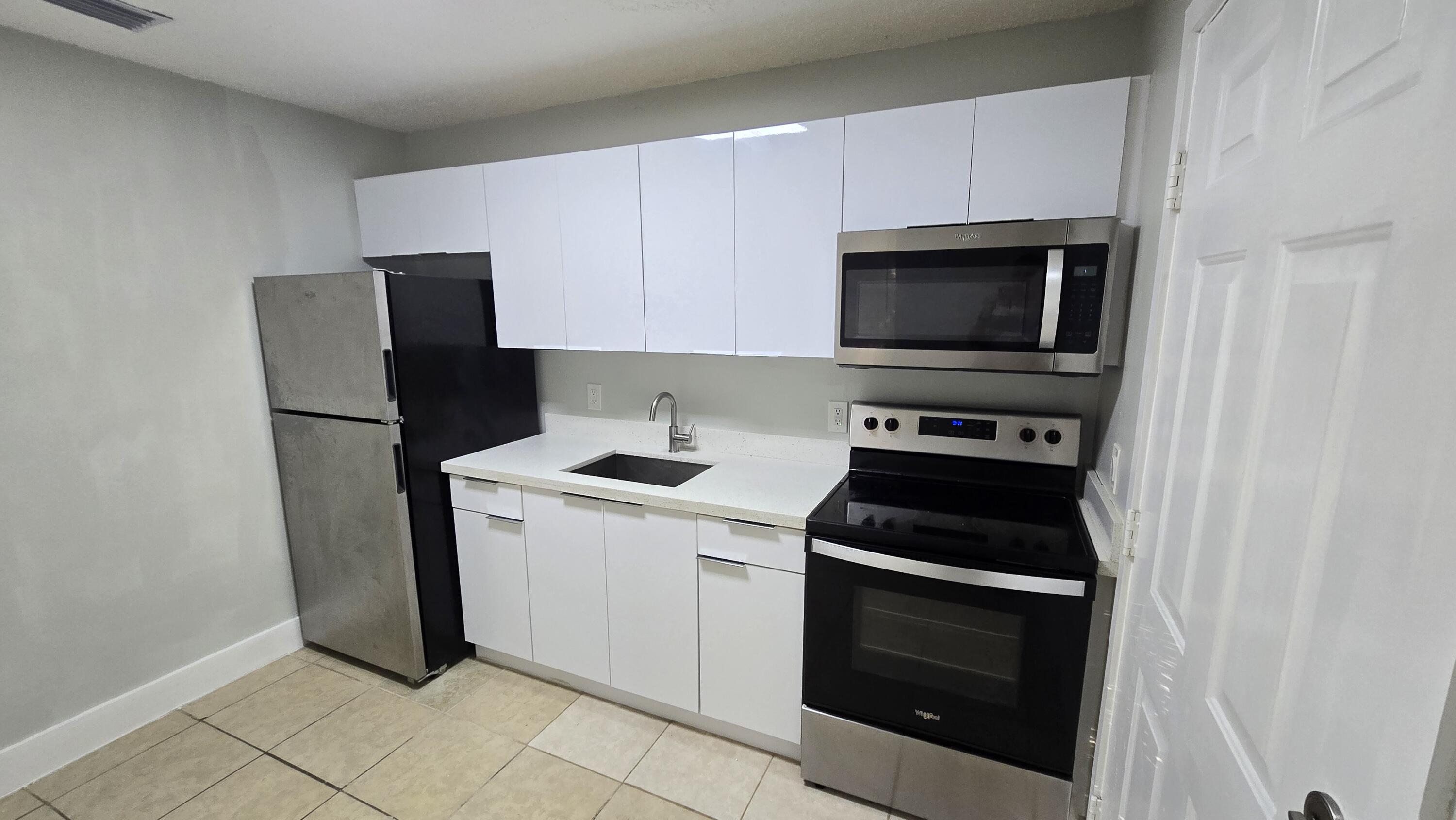 1310 North 16th Street, Unit D Fort Pierce, FL 34950 - Photo 1 of 9 a kitchen with a stove microwave and sink