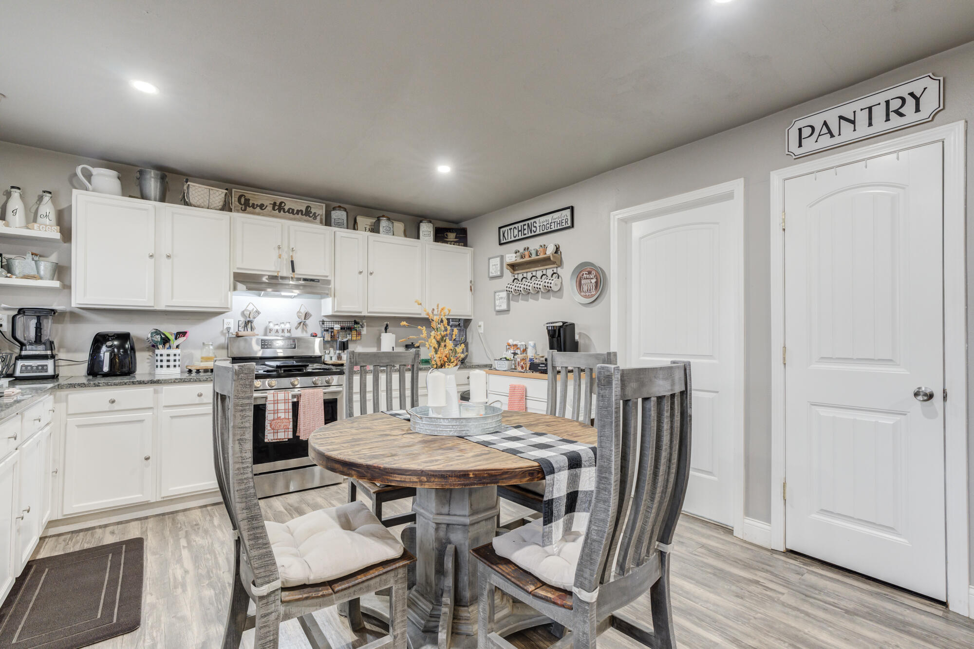 1515 36th Street Lubbock, TX 79412 - Photo 7 of 23 a kitchen with stainless steel appliances a dining table chairs and a refrigerator