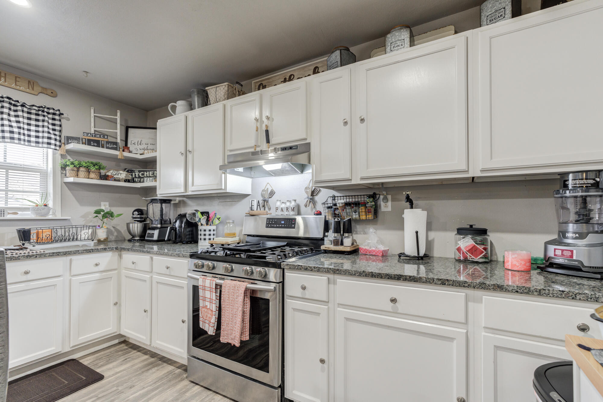 1515 36th Street Lubbock, TX 79412 - Photo 9 of 23 a kitchen with granite countertop white cabinets and white appliances