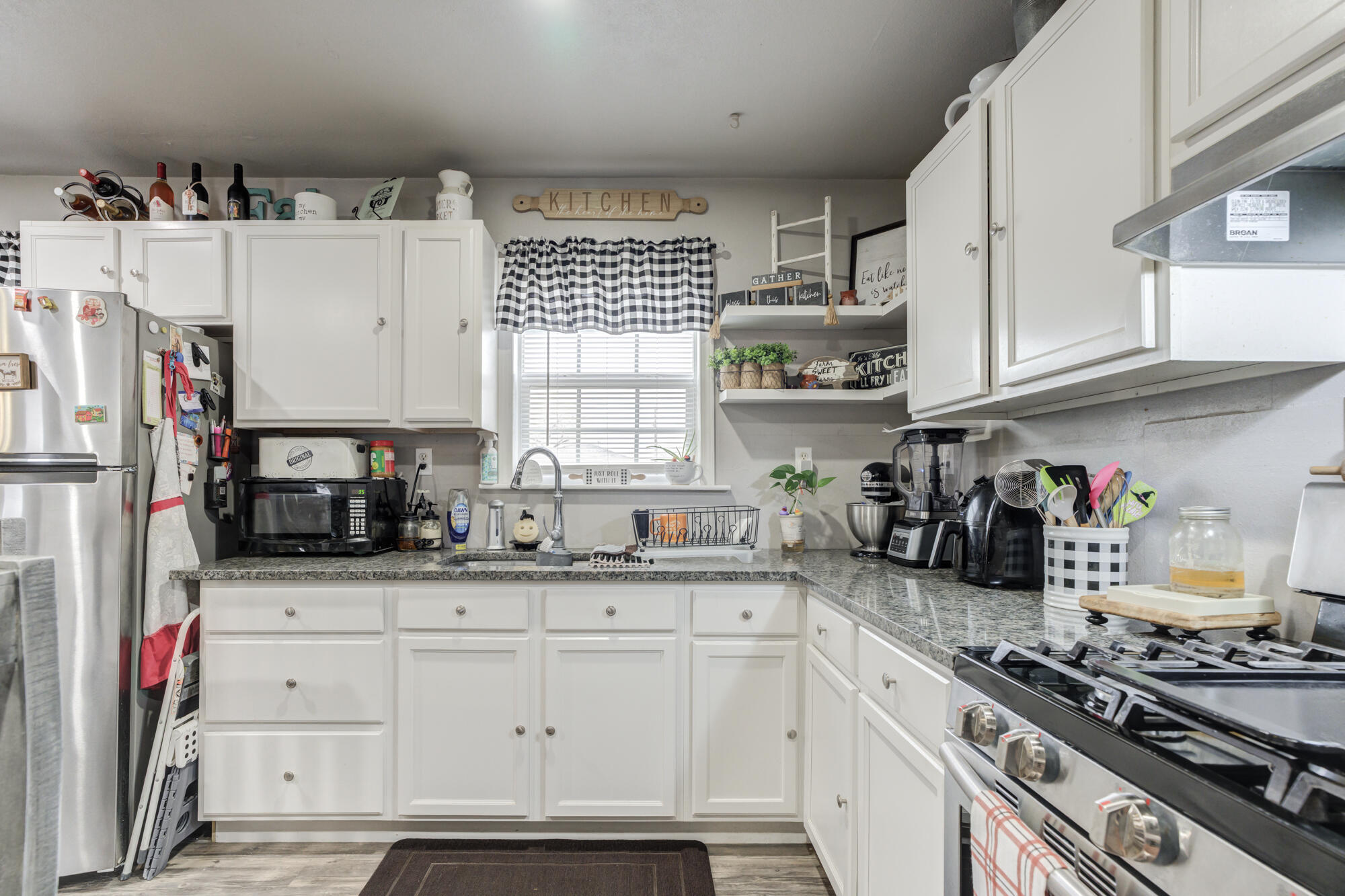 1515 36th Street Lubbock, TX 79412 - Photo 10 of 23 a kitchen with stainless steel appliances granite countertop a stove and cabinets
