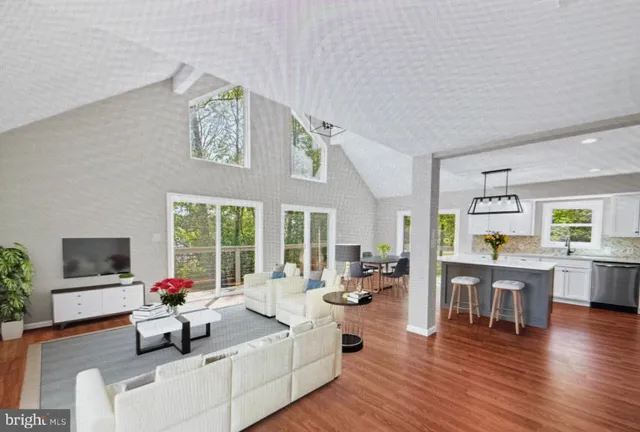 a living room with furniture flat screen tv and wooden floor