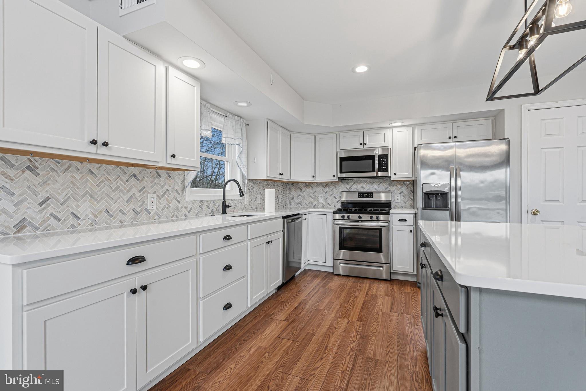 6812 Schaadts Road, Unit 6812 Middle River, MD 21220 - Photo 4 of 54 a kitchen with granite countertop white cabinets and stainless steel appliances