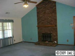 12616 Newstead Road Huntersville, NC 28078 - Photo 2 of 8 an empty room with a fireplace and window