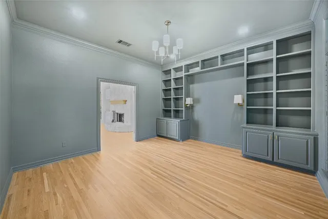 a view of empty room with wooden floor and cabinet